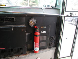 a fire extinguisher mounted at the bus entrance door